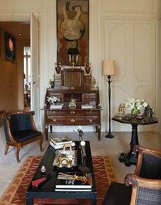 a living room filled with furniture and a painting on the wall