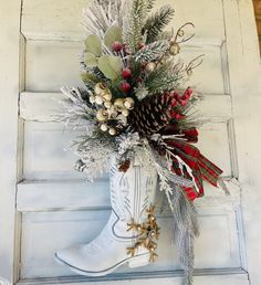 a white boot with christmas decorations hanging on the side of a wall next to a door