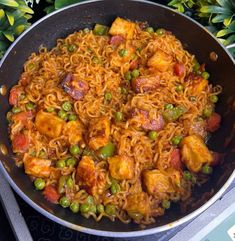 a pan filled with noodles and vegetables on top of a stove