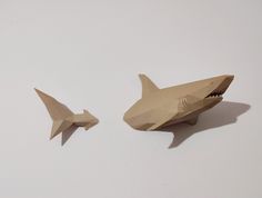 two origami shark shaped objects on a white surface