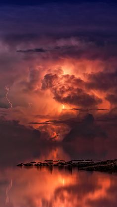 the sky is reflected in the water as it looks like clouds are coming from behind