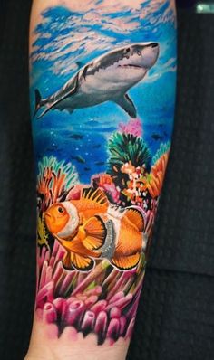 an arm with a shark and clown fish on it