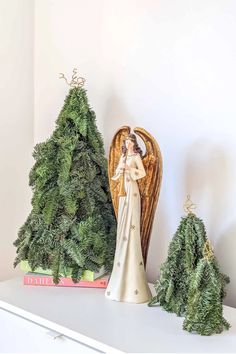 a figurine sitting on top of a white shelf next to christmas tree decorations