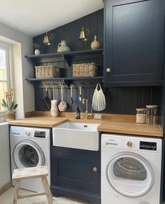 a washer and dryer in a small room with shelves on the wall behind them