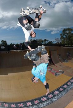 two men doing tricks on skateboards at a skate park