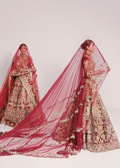 two women in red and gold wedding gowns, one with a veil over her head