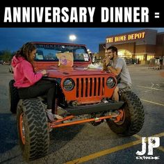 a man and woman sitting on top of an orange jeep in front of a home depot