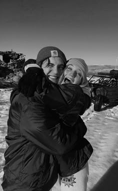 two people hugging each other in the snow