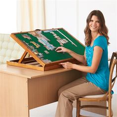 a woman sitting at a desk with a board game in front of her on it