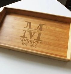 a personalized bamboo tray with the initials and date engraved on it, sitting on a table