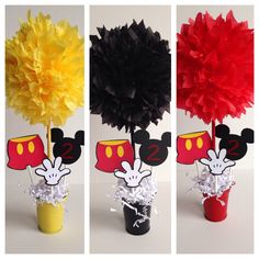 three different types of paper flowers in small vases with mickey mouse decorations on them