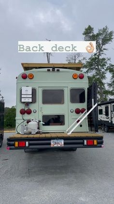 a dog is sitting in the back of a truck with a sign that says back deck