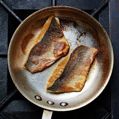 two fish are cooking in a frying pan