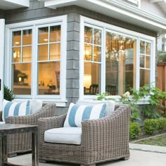 two wicker chairs sitting on top of a patio