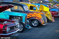 many classic cars are lined up on the street