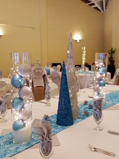 the table is set with silver and blue decorations