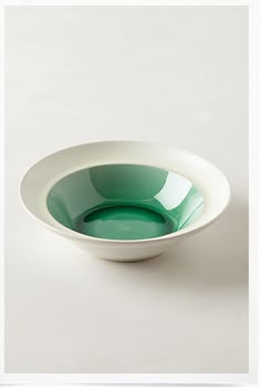 a white and green bowl sitting on top of a table