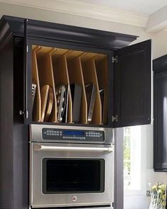 a kitchen with black cabinets and stainless steel appliances in the cupboards that hold utensils