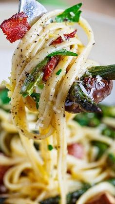 a fork full of spaghetti with asparagus and bacon