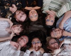 a group of people laying in the middle of a circle with their faces covered by glasses