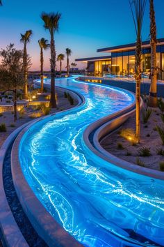 the water slide is lit up at night with palm trees in the foreground and lights on