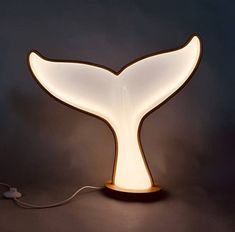 a light that is shaped like a whale's tail on top of a table