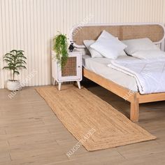 a bed with white sheets and pillows on top of it next to a wooden floor