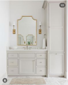 a white bathroom with two sinks and a large mirror over it's vanity area