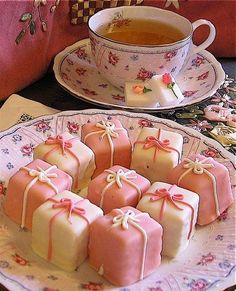 tea party for easy entertaining with pink and white treats on a plate next to a cup of tea