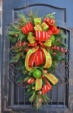 a green and red christmas wreath on a door