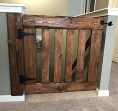 a wooden gate in the corner of a room next to a wall and carpeted floor