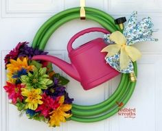 a wreath with a watering can and flowers on it