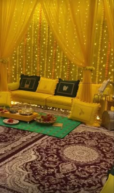 a living room decorated in yellow and red with lights on the walls, couches and rugs