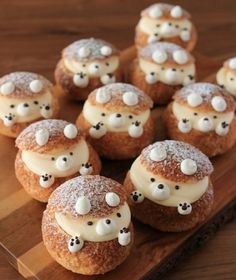 small pastries with white frosting and teddy bears on them sitting on a wooden plate