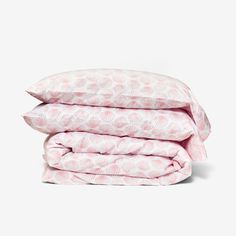 three sheets stacked on top of each other in pink and white print, with one folded up