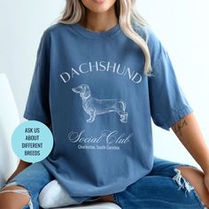 a woman sitting on top of a toilet wearing a shirt with a dachshund