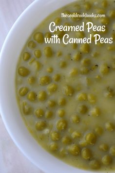 a white bowl filled with green peas and garnished pea soup on top of a table