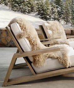 a wooden chair sitting on top of a snow covered ground next to a fire place