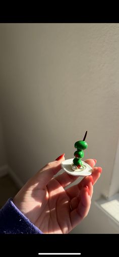 a person holding a toothbrush in their hand with green stuff on top of it