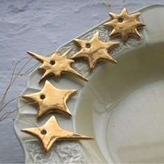 five gold stars are placed on a white plate