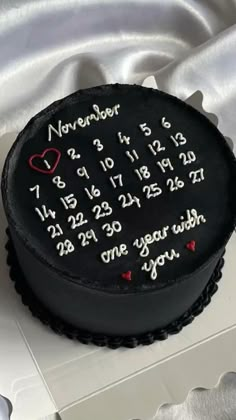 a black cake with white frosting and red hearts on it's side that says, november