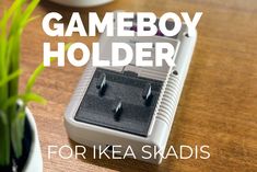 the gameboy holder for ikea skadis is sitting next to a potted plant