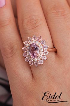 a woman's hand with a pink diamond ring on her finger and an engagement band