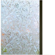 a frosted glass window with flowers and leaves on the outside, behind it is a white wall