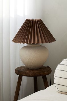 a white lamp sitting on top of a wooden table