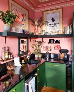 a kitchen with pink walls and green cabinets