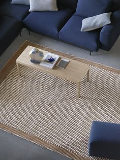 a living room with blue couches and a coffee table in the middle on a rug