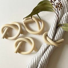 three pieces of white wood sitting on top of a table next to a plant with leaves