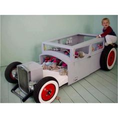 a little boy sitting on top of a toy car