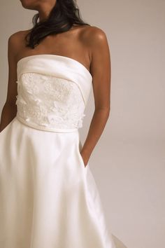 a woman in a white dress is posing for the camera